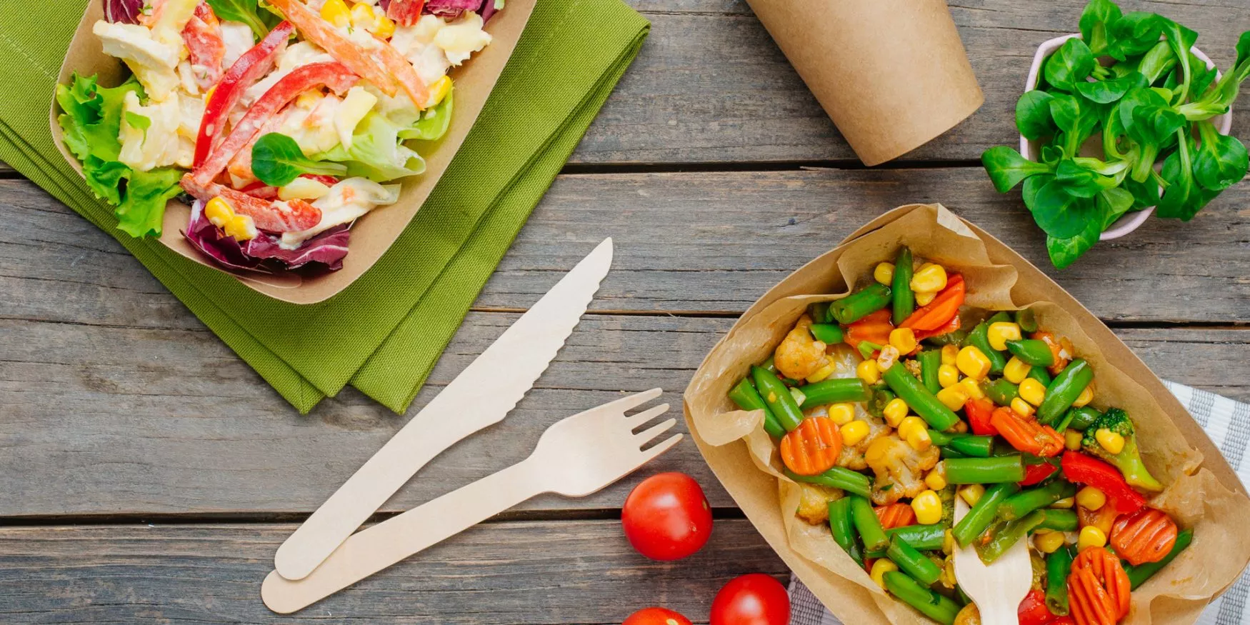 Salades variées dans des emballages en carton durable, avec des couverts en bois ; Salads in sustainable cardboard packaging, with wooden cutlery ; Verschiedene Salate in Verpackungen aus nachhaltigem Karton mit Holzbesteck