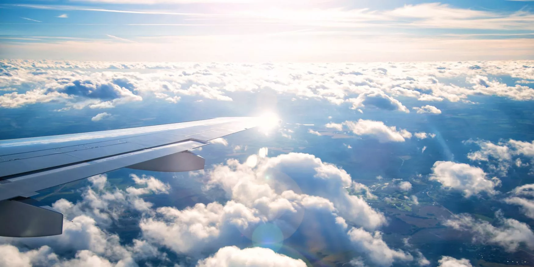 Point de vue depuis un avion dans le ciel où l'on voit son aile ; View from a plane in the sky where you can see its wing ; Blickpunkt aus einem Flugzeug am Himmel, bei dem man den Flügel sieht