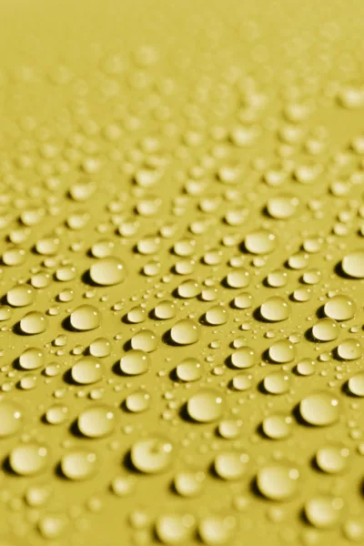 gouttes d'eau sur un matériau de surface jaune ; water droplets on a yellow surface material ; Wassertropfen auf einem gelben Oberflächenmaterial