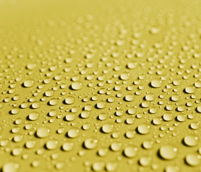 gouttes d'eau sur un matériau de surface jaune ; water droplets on a yellow surface material ; Wassertropfen auf einem gelben Oberflächenmaterial