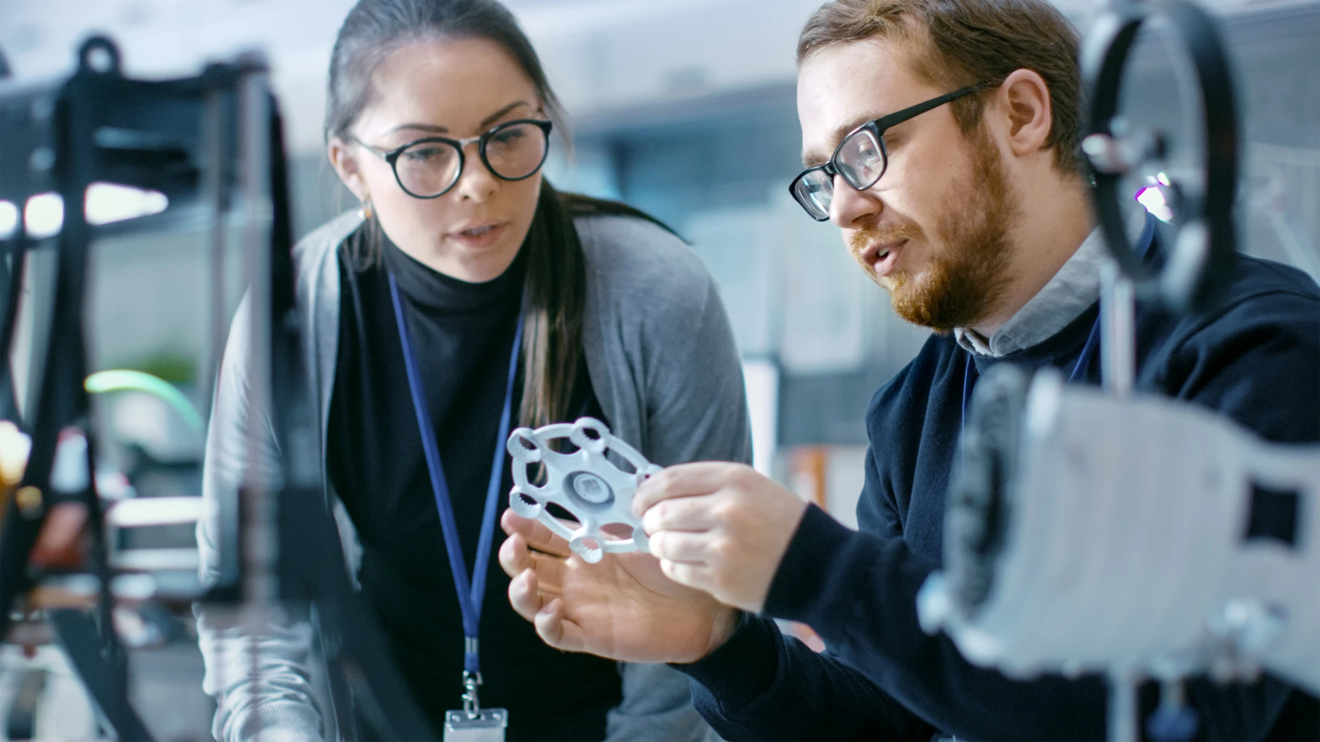 Deux experts en innovation de technologie industrielle, examinent une pièce de production ; Two industrial technology innovation experts examine a production part ; Zwei Experten für industrielle Technologie-Innovation, untersuchen ein Produktionsstück